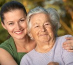 Woman in her late twenties embracing a senior lady