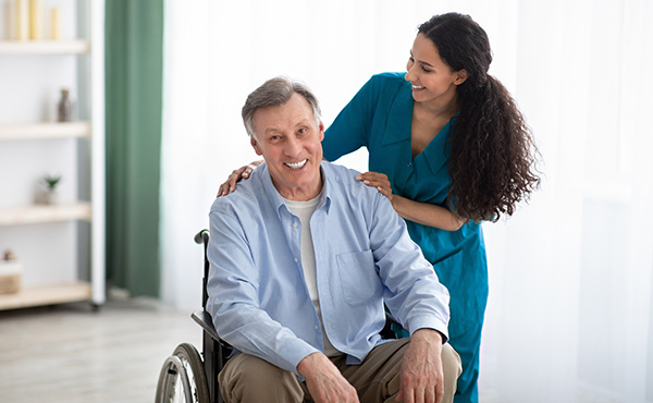 Homme en fauteuil roulant avec son auxiliaire de vie